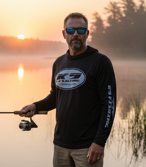 Angler wearing K9 Fishing black long sleeve hooded tee fishing at sunset on the water